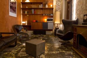 a living room with a couch and chairs and a table at Hôtel La Nouvelle République & Hammam in Paris
