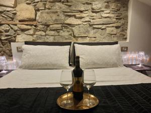 a bed with a bottle of wine and two glasses at Luxury Room La Terrazza sul Lago di Como in Blevio
