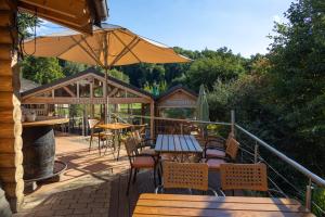 an outdoor patio with tables and chairs and an umbrella at Carolinger Hüttendorf in Weyer