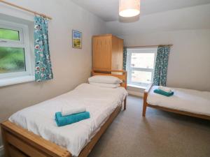 - une petite chambre avec 2 lits et une fenêtre dans l'établissement East Bank Cottage, à Matlock
