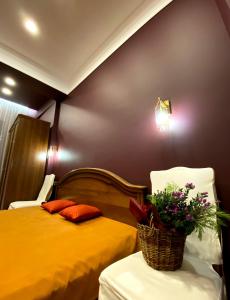 a bedroom with a yellow bed and a basket of flowers at Квартира студия in Almaty