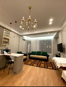 - un salon avec un canapé et un lustre dans l'établissement Квартира студия, à Almaty