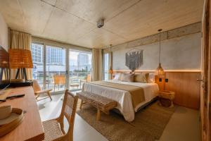 a bedroom with a large bed and a desk and a desk at Ambar Hotel in Punta del Este