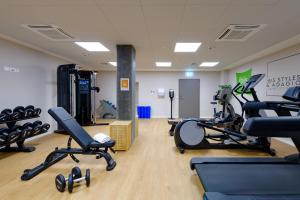 una palestra con tapis roulant e sedie in una stanza di ibis Styles Zurich City Center a Zurigo