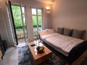 1 dormitorio con cama, mesa y ventanas en Exclusive Wohnung im Zentrum, RB Stadion & Arena! en Leipzig