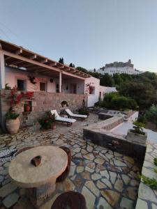 Patmos Chora traditional villa Genadio في باتموس: باحة حجرية مع طاولة ومبنى