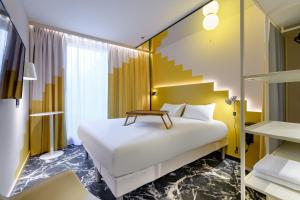 una camera d'albergo con letto e scala di ibis Styles Zurich City Center a Zurigo