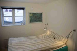 łóżko w sypialni z oknem w obiekcie Nice and cozy flat w mieście Nuuk