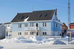a blue and white house with snow in front of it at Nice and cozy flat in Nuuk
