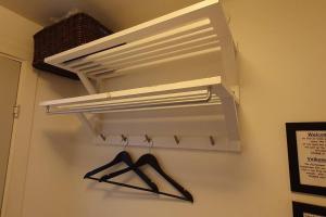 una estantería blanca con un par de perchas en la pared en Nice and cozy flat, en Nuuk 9 fotos más