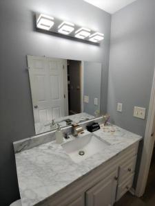 baño con lavabo y espejo grande en Relaxing Cottage by the Lake and Parking, en Pontiac