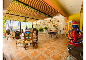 a dining room with a table and chairs and a room with a game at Hotel Hacienda Real in Bernal