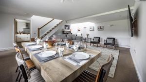 a dining table and chairs in a living room at Stunning Barn Conversion with HOT TUB and ALPACAS - Ty Cerrig Barn in Corwen