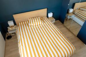 1 dormitorio con 1 cama con colcha a rayas en Le Saint Jame, proche Parc Rivière, en Burdeos