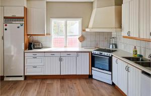 een keuken met witte kasten en een witte koelkast bij 6 Bedroom Nice Apartment In Vallsta in Vallsta