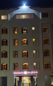 a building with many windows with lights on it at Muscat Horizon Hotel in Mawāliḩ