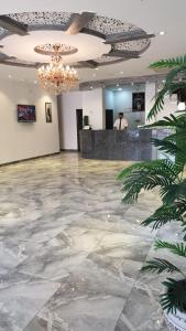 vestíbulo con suelo de mármol y lámpara de araña en Muscat Horizon Hotel, en Mawāliḩ