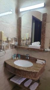 a bathroom with a sink and a large mirror at Muscat Horizon Hotel in Mawāliḩ