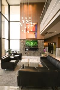 a living room with black leather furniture and a chandelier at Grand Resort Hotel - Mt Laurel - Philadelphia in Mount Laurel