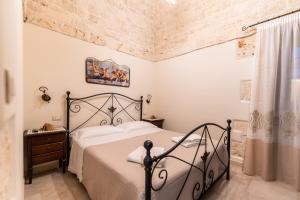 1 dormitorio con cama y pared de ladrillo en B&B Panaro, en Alberobello