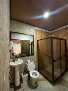 a bathroom with a shower and a toilet and a sink at Hotel Sunset Rooms in Tortuguero