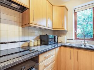 a kitchen with a sink and a microwave at Llety Nest in Llanfachreth