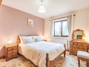 a bedroom with a large bed and a window at Llety Nest in Llanfachreth