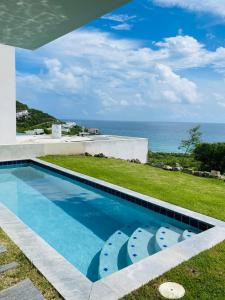 a swimming pool with a view of the ocean at Beautiful 3 bed-roms Sea View Villa at INDIGO BAY in Koolbaai