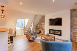 a living room with a couch and a fireplace at Soft time - Luxury flat - Historic Centre Honfleur in Honfleur