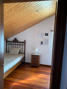 1 dormitorio con cama y techo de madera en Beachfront Surf & Remote Work House, en Valdoviño