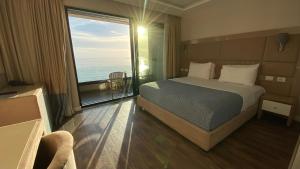 a hotel room with a bed and a large window at Royal G Hotel and Spa in Durrës