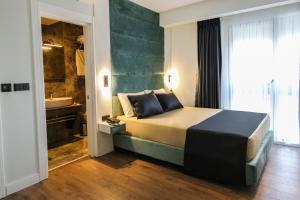 a bedroom with a bed and a bathroom with a sink at AXU AIRPORT HOTEL in Arnavutköy