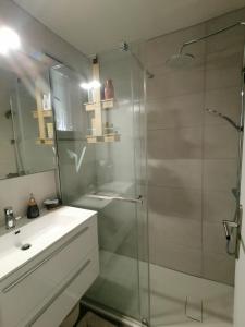 La salle de bains est pourvue d'une douche en verre et d'un lavabo. dans l'établissement LE SOLEIL D'OR, à Sainte-Maxime