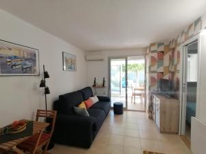 ein Wohnzimmer mit einem Sofa und einem Tisch in der Unterkunft LE SOLEIL D'OR in Sainte-Maxime