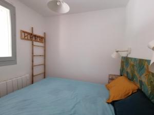 ein kleines Schlafzimmer mit einem blauen Bett und einem Fenster in der Unterkunft LE SOLEIL D'OR in Sainte-Maxime