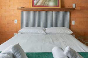 - un grand lit blanc avec 2 oreillers dans l'établissement Apto 2 quartos na Rua 2950, Wifi e Garagem Grande P1232, à Balneário Camboriú