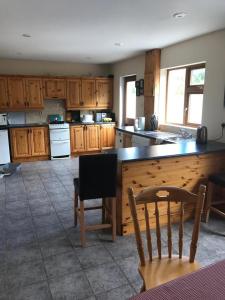 a kitchen with wooden cabinets and a table and chairs at Atlantic View in Castlegregory