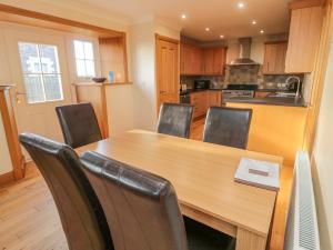 a kitchen with a wooden table and chairs at Long Cart Cottage in Embleton