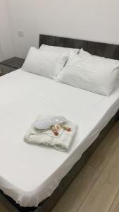 Una cama blanca con una toalla blanca. en Le bougainvillea 1, en Corbetta