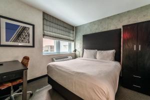 sypialnia z dużym łóżkiem z biurkiem i łóżkiem o wymiarach 6 x 6 x 6 x 6 w obiekcie Solita Soho Hotel w Nowym Jorku