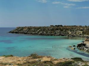 two people standing in the water at a beach at Casa Sofia Favignana in Favignana