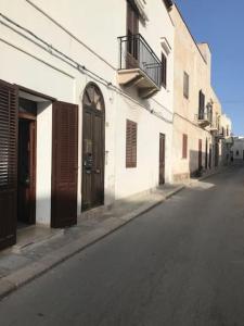 an empty street next to a white building at Casa Sofia Favignana in Favignana
