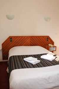 Una habitación de hotel con una cama con dos toallas. en La Taverne des Deux Augustins, en Étretat