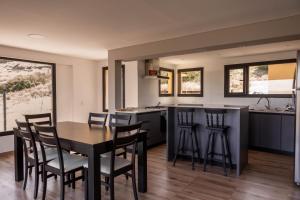 a kitchen with a black table and chairs in a kitchen at El Mirador in Esquel