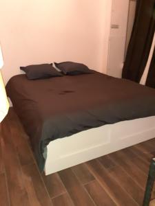 uma cama com um edredão preto num quarto em Le cocon em Dijon