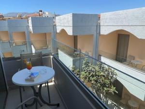 - une table sur un balcon avec une boisson dans l'établissement Hotel Kathrin Beach, à Adelianos Kampos