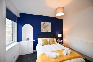 1 dormitorio con paredes azules y 1 cama con toallas en The Wee Lion, en Troon