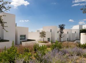 una fila de edificios blancos con plantas en el primer plano en Villa La Perla Sotogrande - since 2022 - Sea View - 3 Bedrooms and Bathrooms - La Reserva Beach and Golf nearby en Sotogrande