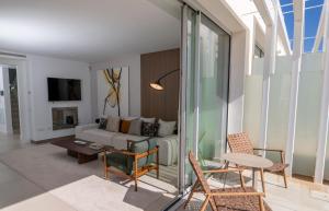 a living room with a couch and a table and chairs at Villa La Perla Sotogrande - since 2022 - Sea View - 3 Bedrooms and Bathrooms - La Reserva Beach and Golf nearby in Sotogrande