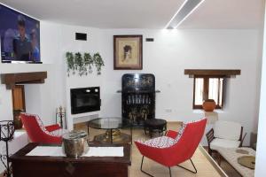 a living room with red chairs and a table at Molino de La Médica Casa Rural de Lujo en Gredos in Candeleda